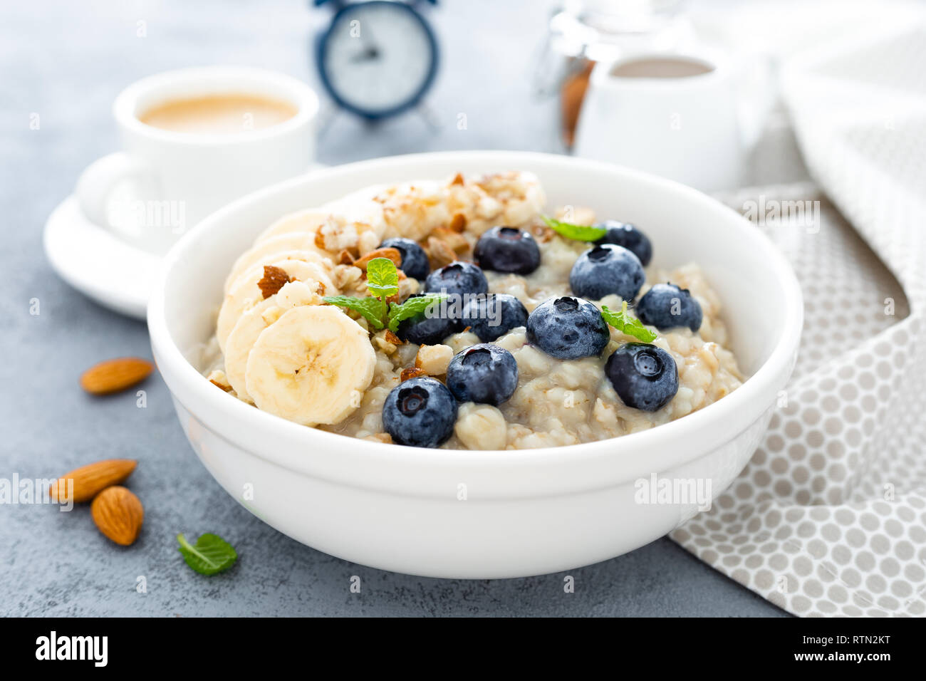 Farina di avena con mirtilli freschi, banana, mandorla noci e miele per la colazione Foto Stock