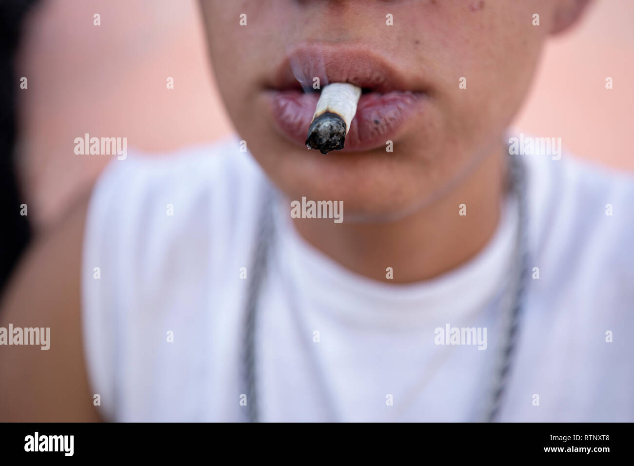 Giovane uomo di fumare un sigaro di marijuana Foto Stock
