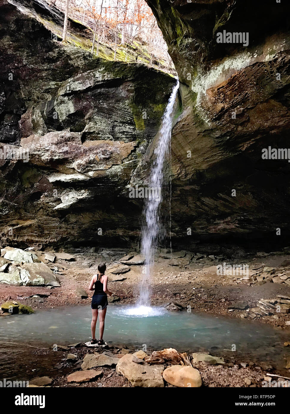 Ragazza cerca fino ad una cascata in una grotta Foto Stock Ragazza cerca fino ad una cascata in una grotta Foto Stock