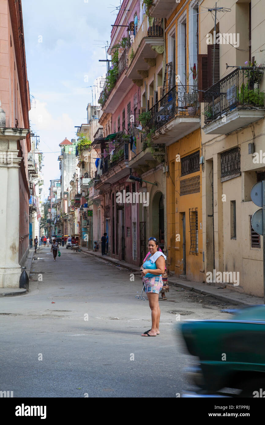 L'Avana, Cuba - 06 Gennaio 2013: una vista delle strade della città con il popolo cubano. Una donna è in piedi in mezzo alla strada, prendere un taxi la fo Foto Stock