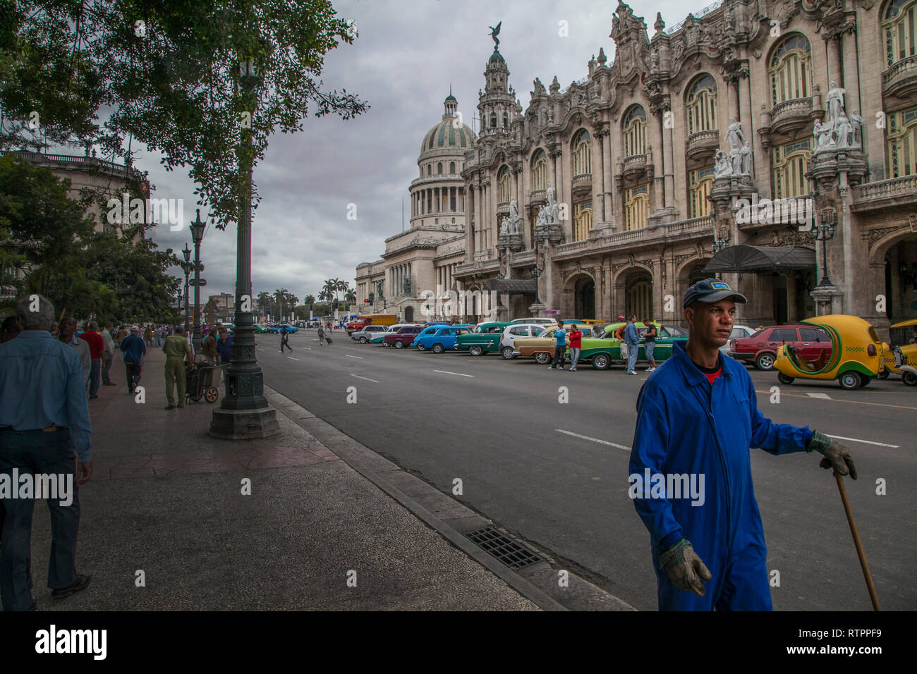 L'Avana, Cuba - 18 Gennaio 2013: una vista delle strade della città con il popolo cubano. Una motospazzatrice in primo piano. Foto Stock