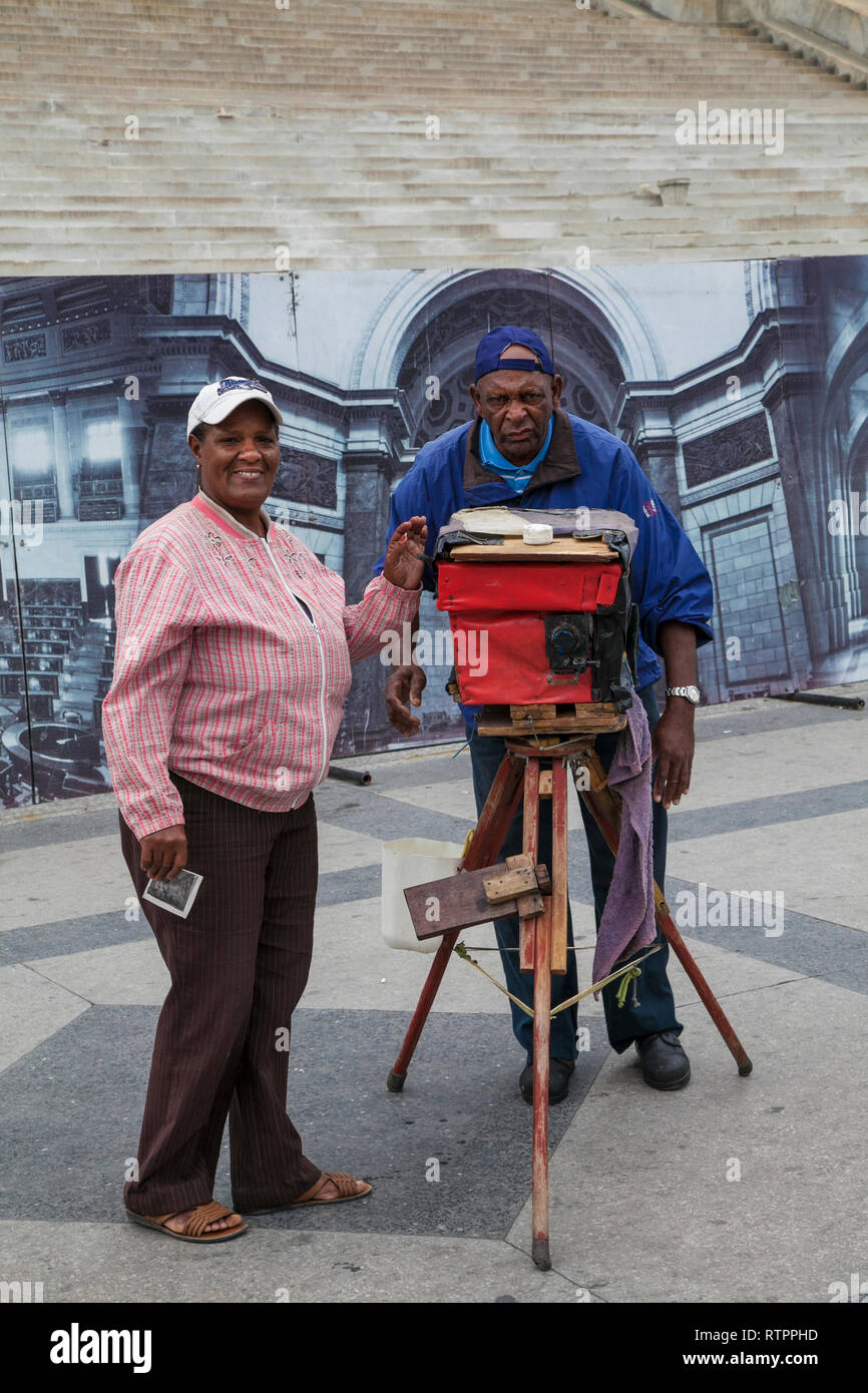 L'Avana, Cuba - 18 Gennaio 2013: una vista delle strade della città con il popolo cubano. Un vecchio uomo fotografare con una fotocamera d'antiquariato. Foto Stock