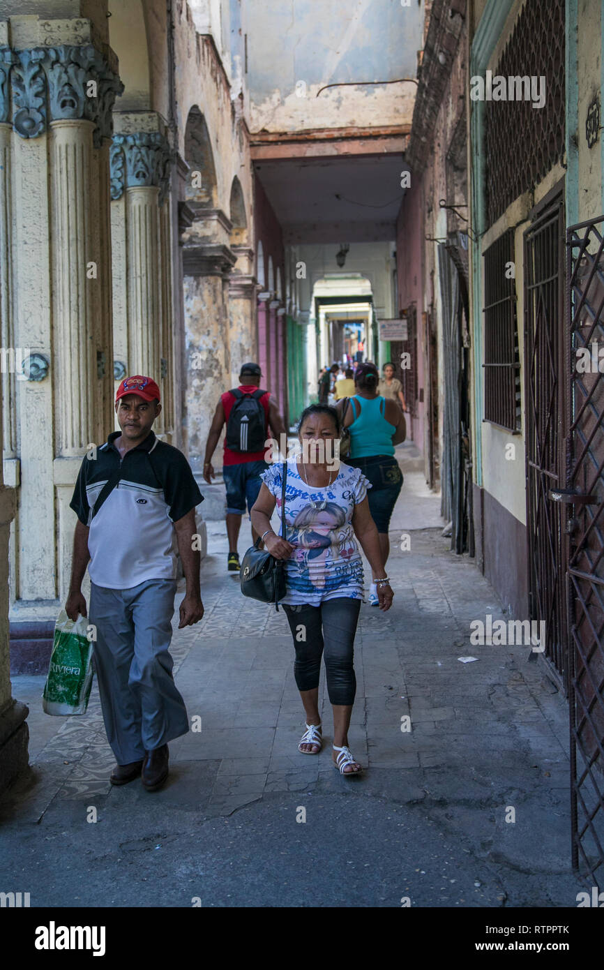 L'Avana, Cuba - 20 Gennaio 2013: una vista delle strade della città con il popolo cubano. Un giovane passa attraverso le arcate. Foto Stock
