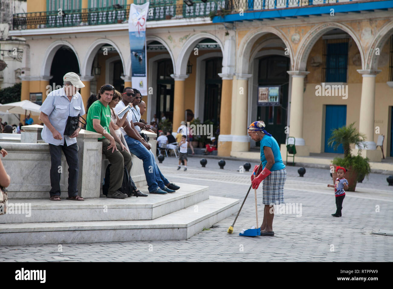 L'Avana, Cuba - 20 Gennaio 2013: una vista delle strade della città con il popolo cubano. Una spazzatrice ritorna in un pozzo di acqua. Foto Stock