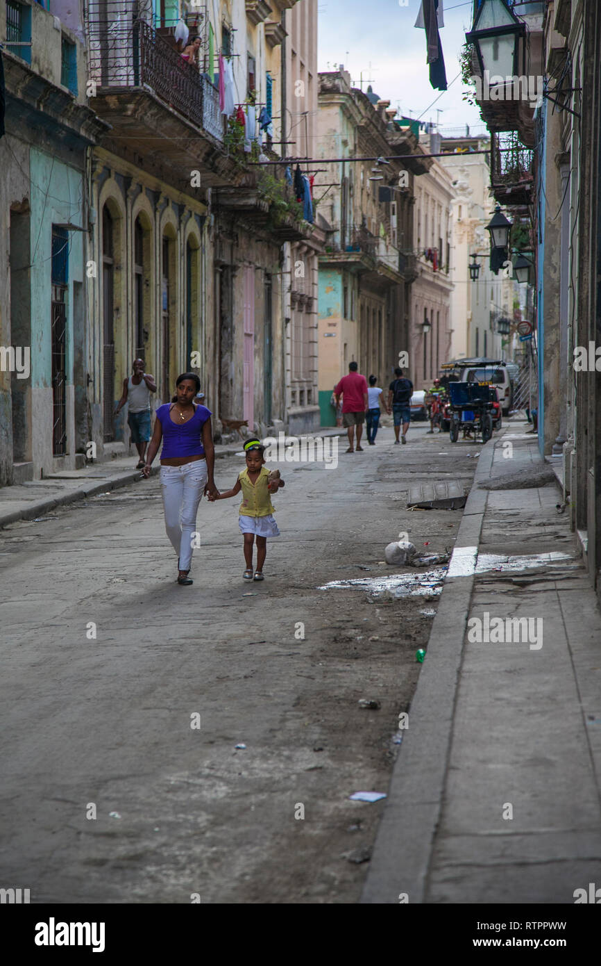 L'Avana, Cuba - 21 Gennaio 2013: una vista delle strade della città con il popolo cubano. Una donna con il bambino va fuori sulla strada. Foto Stock