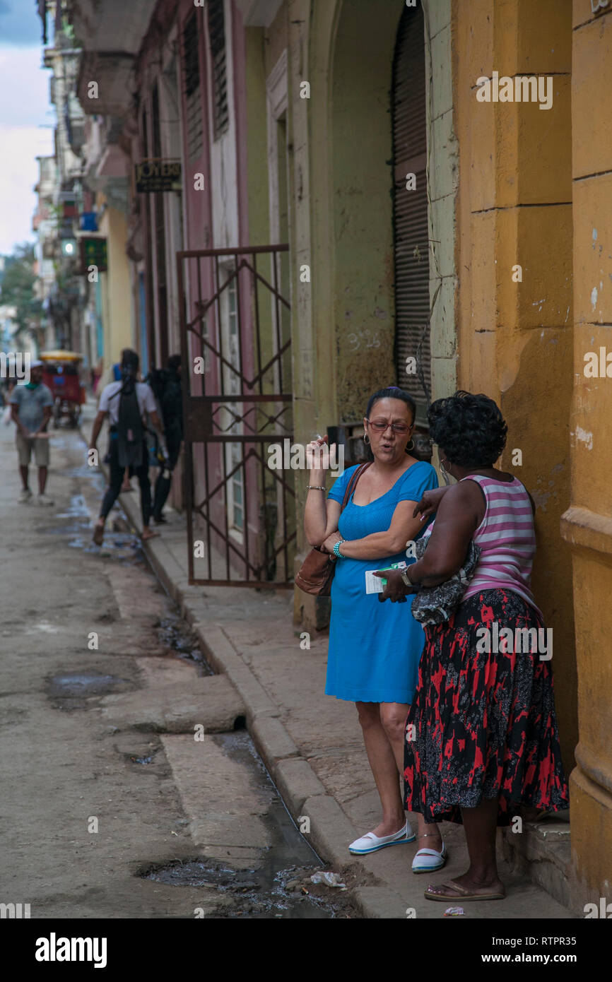 L'Avana, Cuba - 21 Gennaio 2013: una vista delle strade della città con il popolo cubano. Due donne anziane stanno parlando. Foto Stock