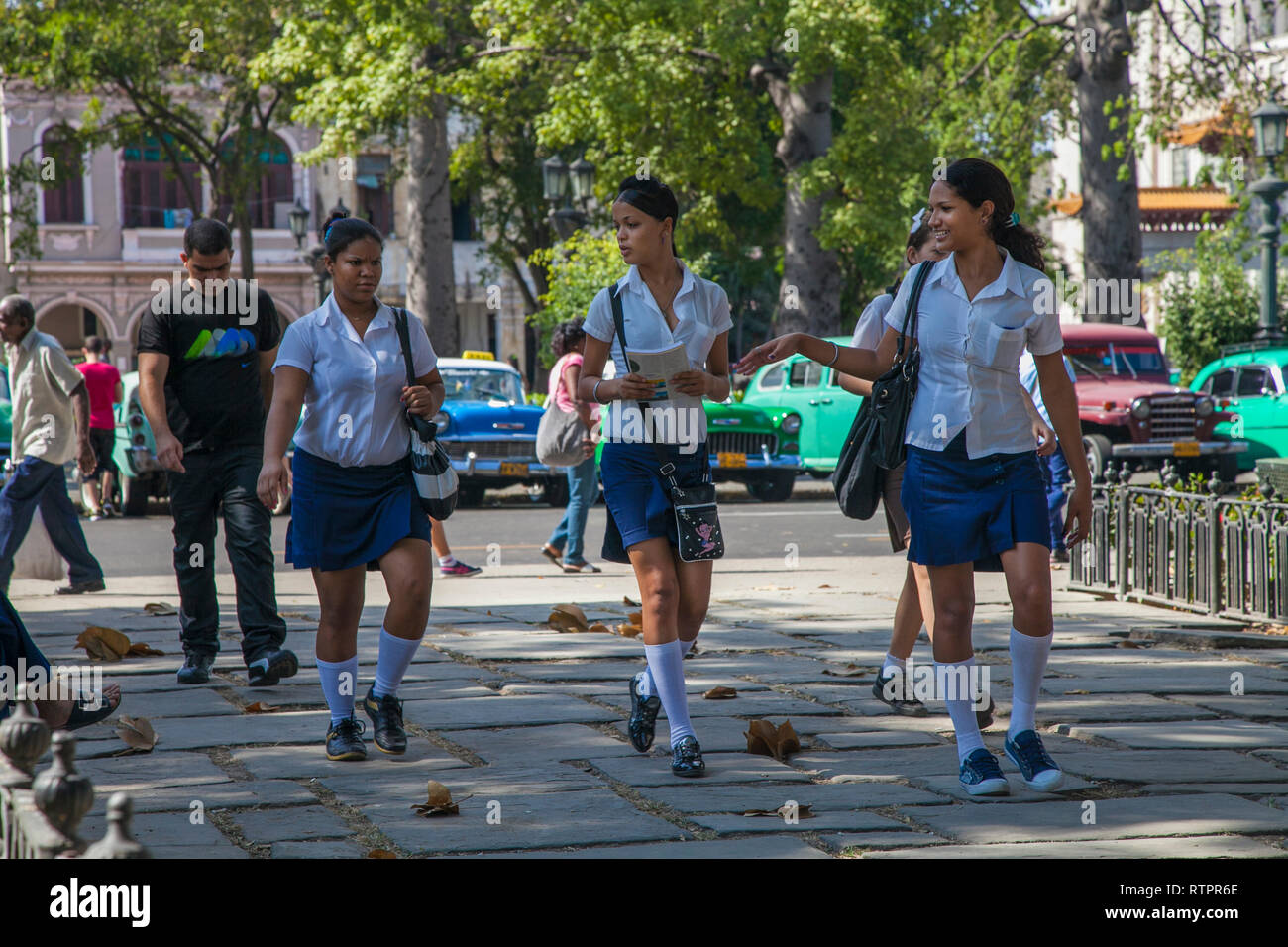 L'Avana, Cuba - 21 Gennaio 2013: una vista delle strade della città con il popolo cubano. Tre studenti di parlare mentre si cammina. Foto Stock