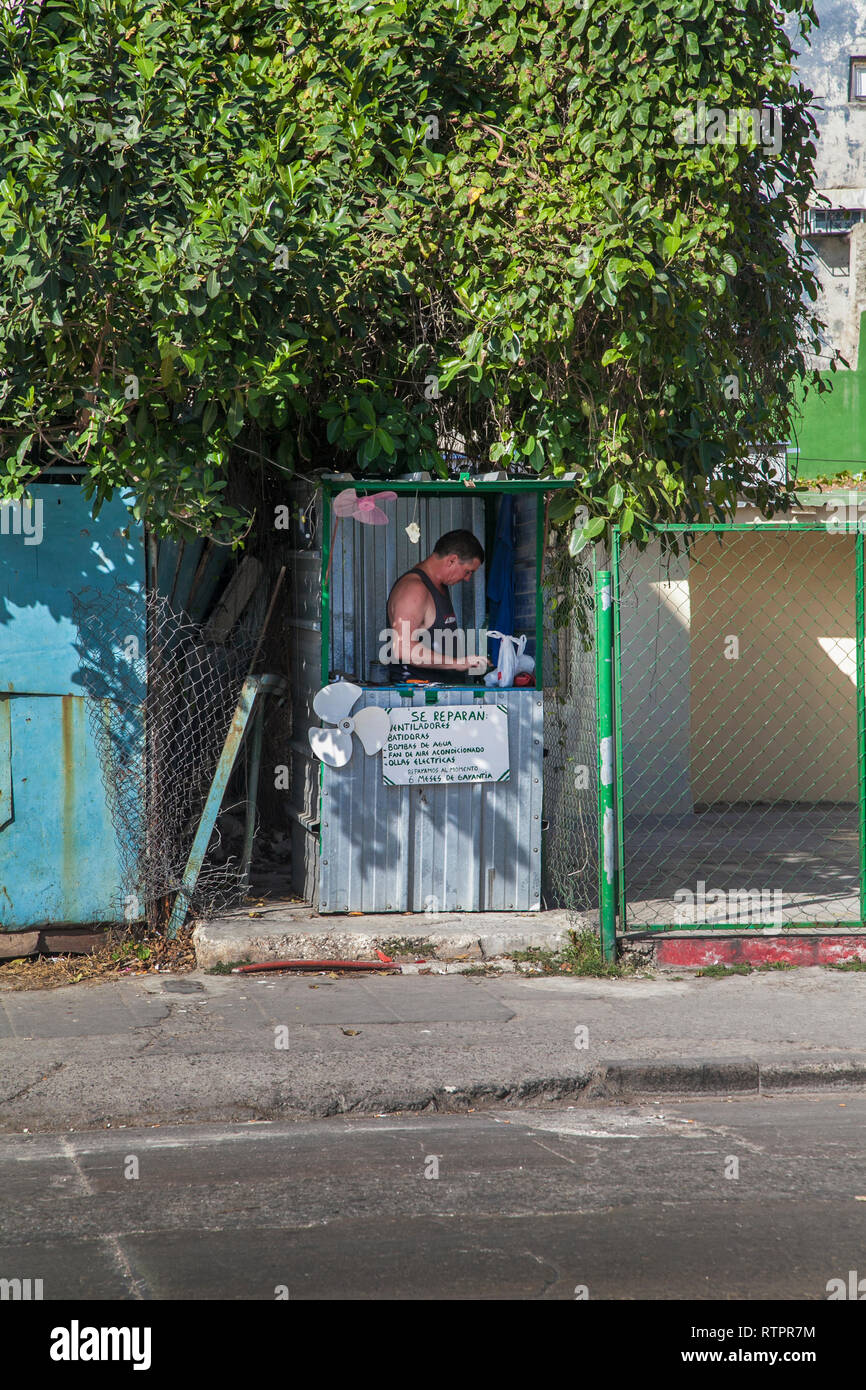 L'Avana, Cuba - 21 Gennaio 2013: una vista delle strade della città con il popolo cubano. Un uomo le riparazioni delle ventole su strada. Foto Stock