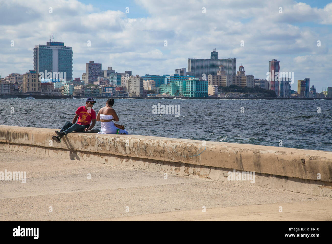 L'Avana, Cuba - 22 Gennaio 2013: una vista delle strade della città con il popolo cubano. Un giovane rilassata sul Seawall Malecon. Foto Stock