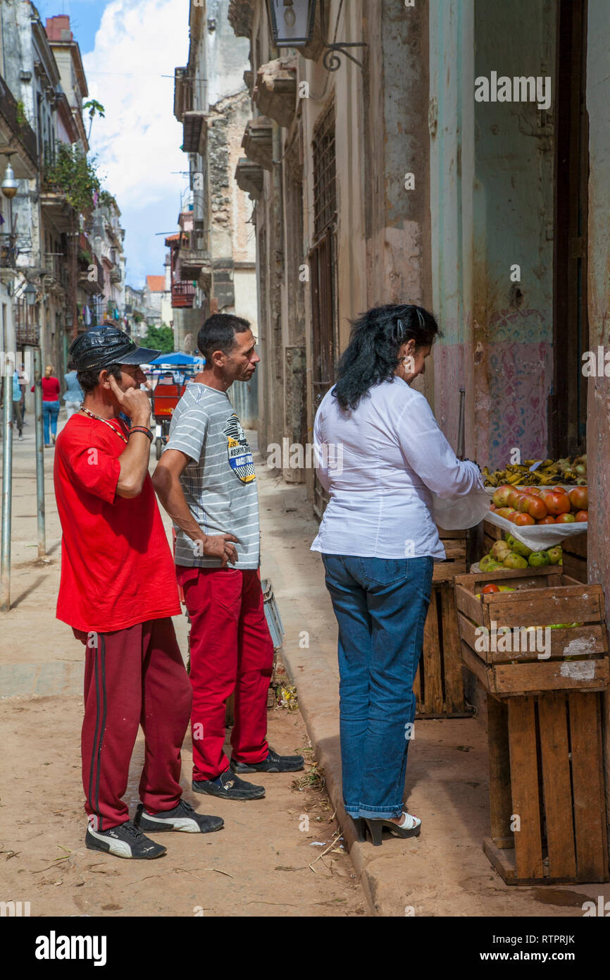L'Avana, Cuba - 24 Gennaio 2013: una vista delle strade della città con il popolo cubano. La gente acquista presso un fruttivendolo. Foto Stock