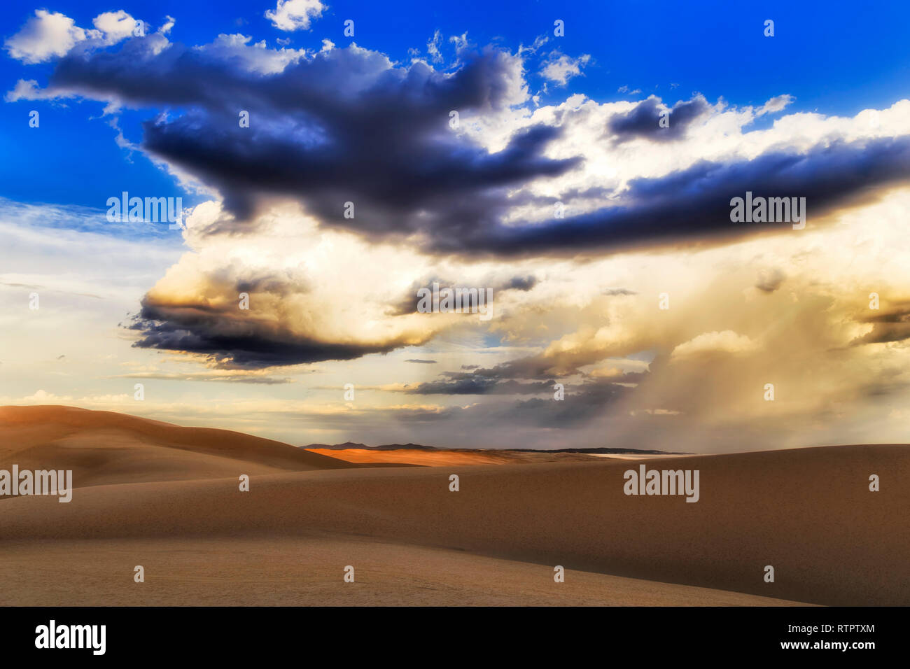 Arido deserto dune di sabbia in Stockton Beach di Australia durante le tempeste con enorme nube strutturato masse in cielo. Foto Stock