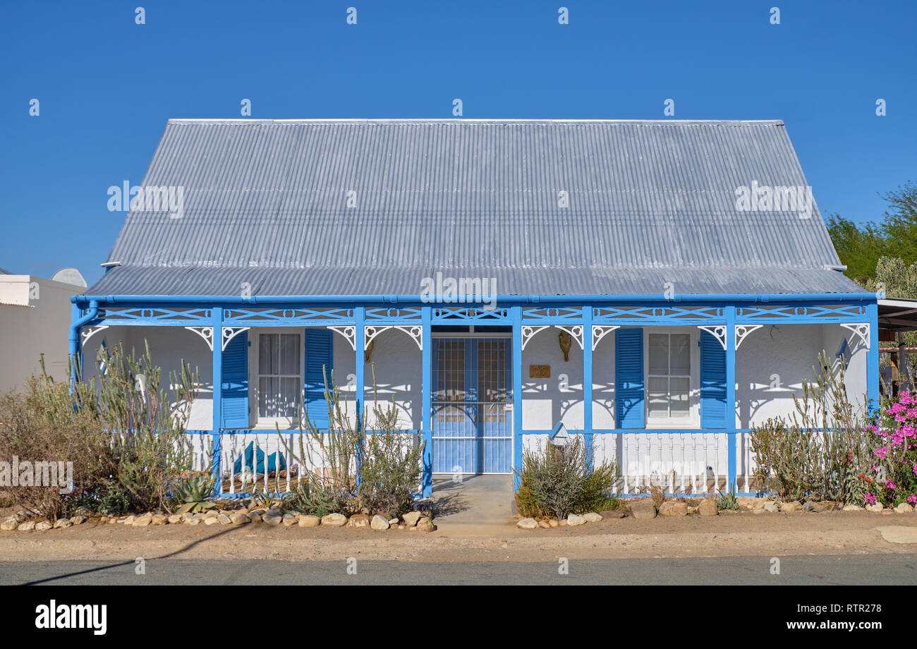 Tradizionale casa Karoo architettura. Blu in stile vittoriano e la casa bianca con tetto dello stagno. In Prince Albert, Sud Africa Foto Stock