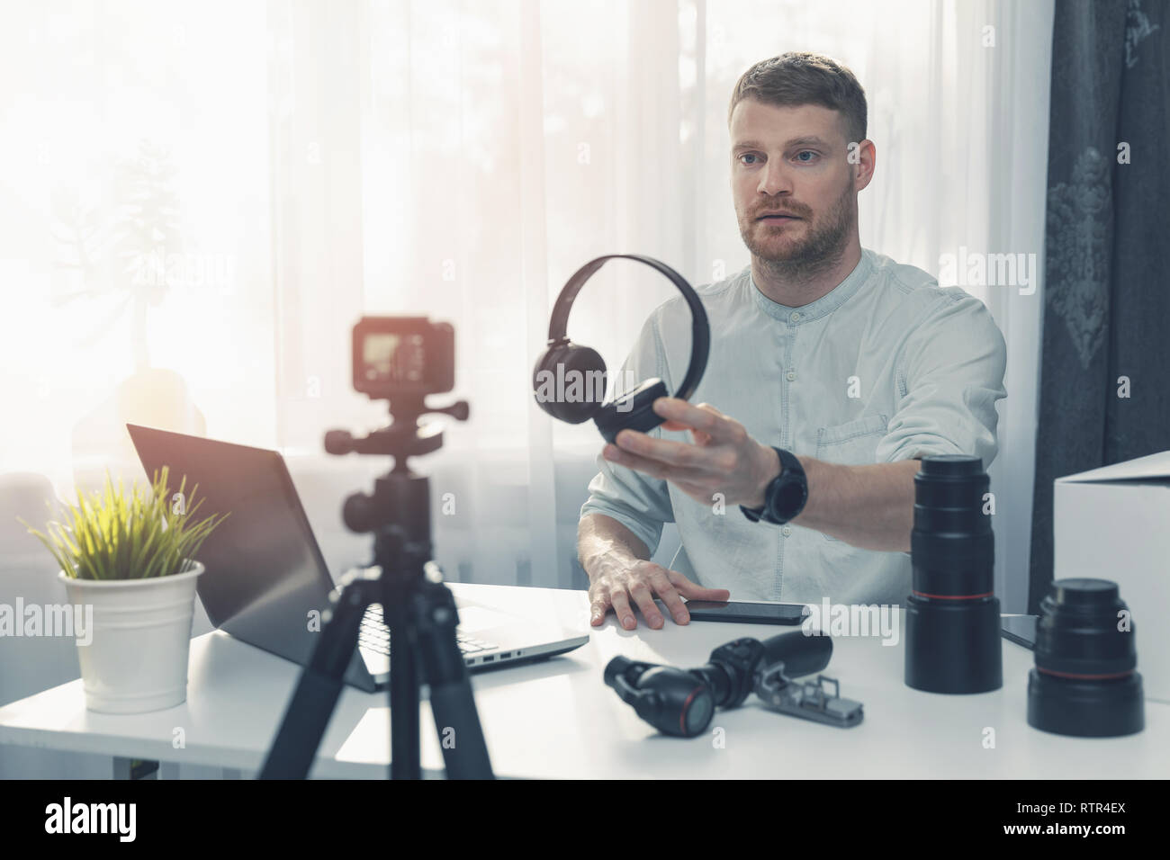 Tecnologia di registrazione di blogger di revisione delle cuffie nella parte anteriore della fotocamera a casa Foto Stock