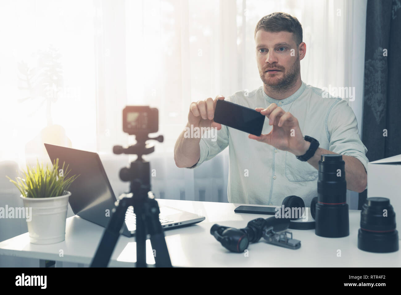 Social media technology vlogger facendo smart phone review nella parte anteriore della fotocamera Foto Stock