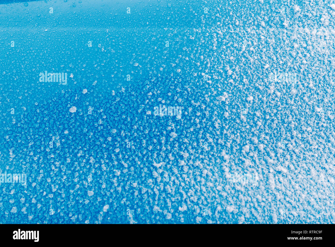 Sticky neve sulla superficie blu. Il ghiaccio, il freddo. Foto Stock