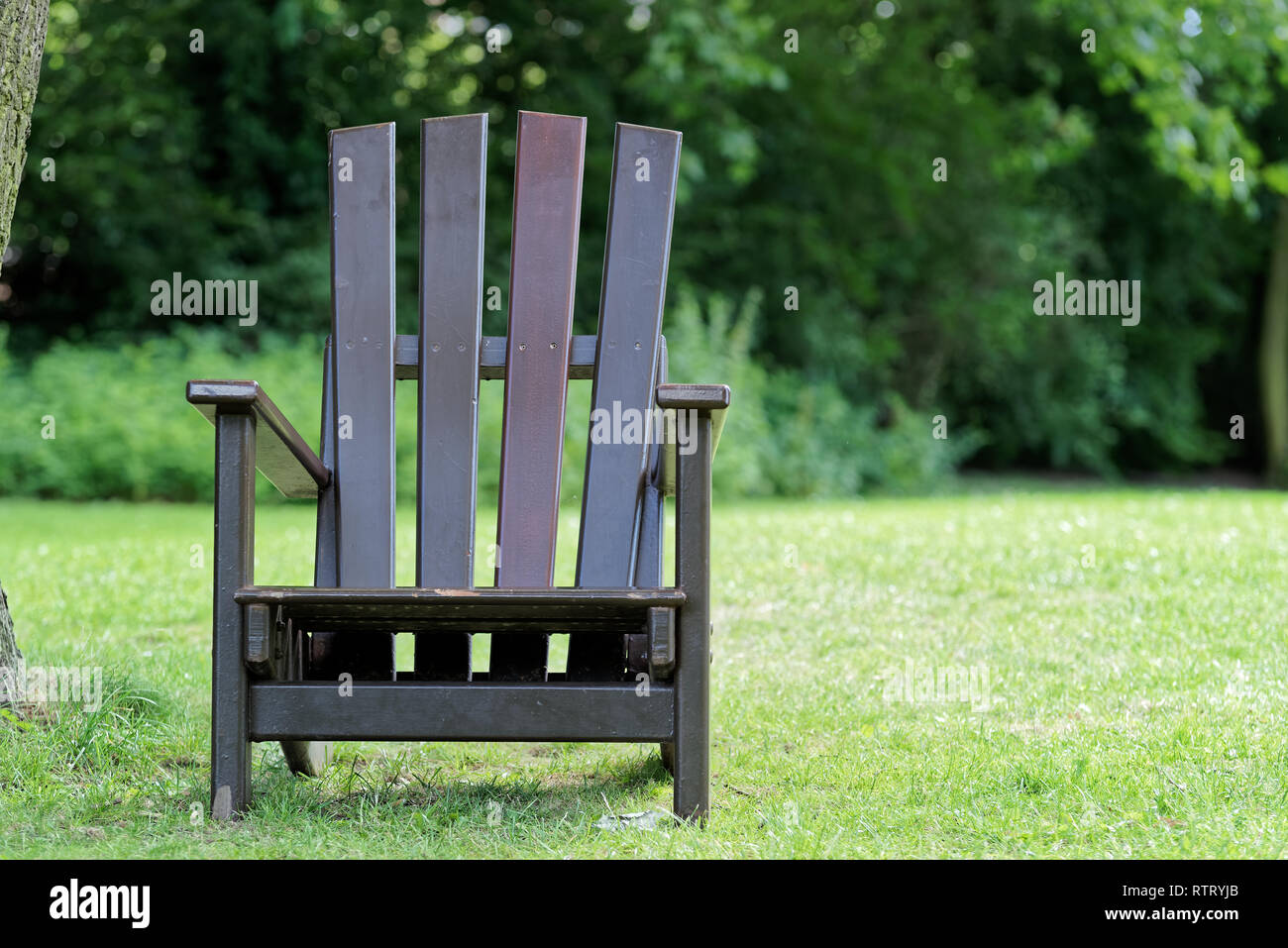 Primo piano della sedia in legno per rilassarsi sul prato verde in un parco pubblico. "Parco Planten un Blomen" giardino della città di Amburgo, Germania Foto Stock