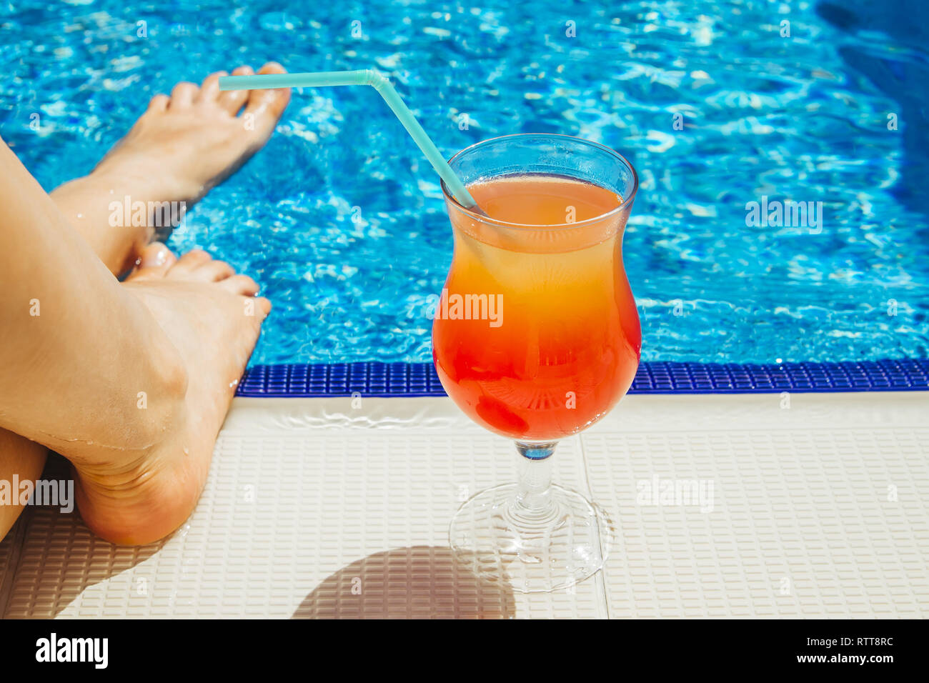 La donna sta avendo un freddo cocktail in piscina Foto Stock