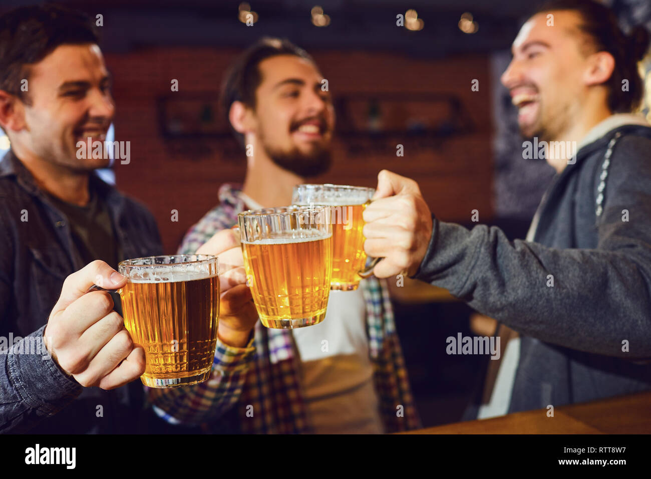 Amici con bicchieri di birra in mano al bar. Foto Stock