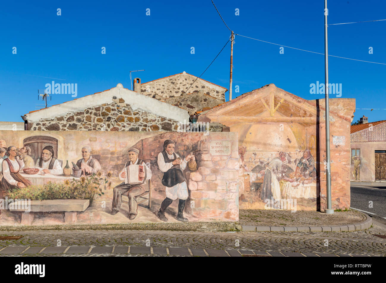 Sardegna Italia su dicembre 27, 2019: murales dipinti sulle case per le strade di Tinnura raffiguranti momenti di zone rurali e la vita del villaggio Foto Stock