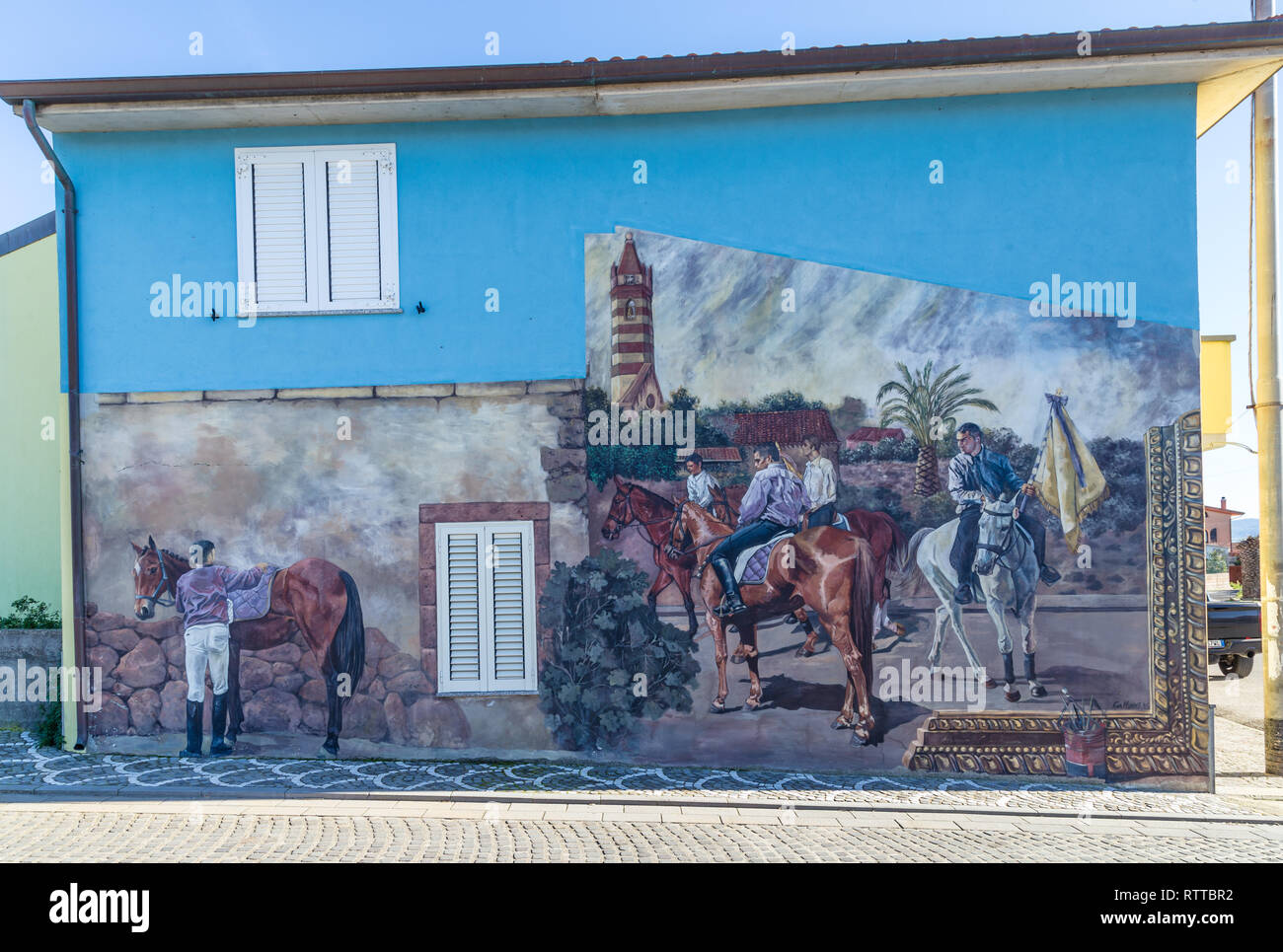 Sardegna Italia su dicembre 27, 2019: murales dipinti sulle case per le strade di Tinnura raffiguranti momenti di zone rurali e la vita del villaggio Foto Stock
