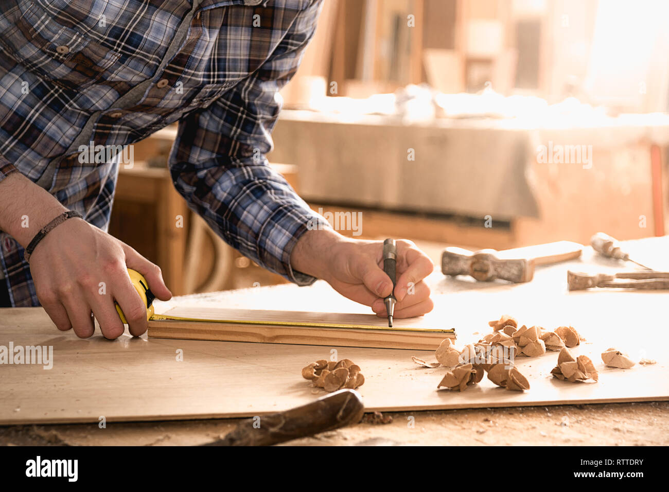 Carpenter lavora con il misuratore o una regola di prendere misure di legno utilizzando una matita. Workshop sullo sfondo. Carpenter workbench. Foto Stock