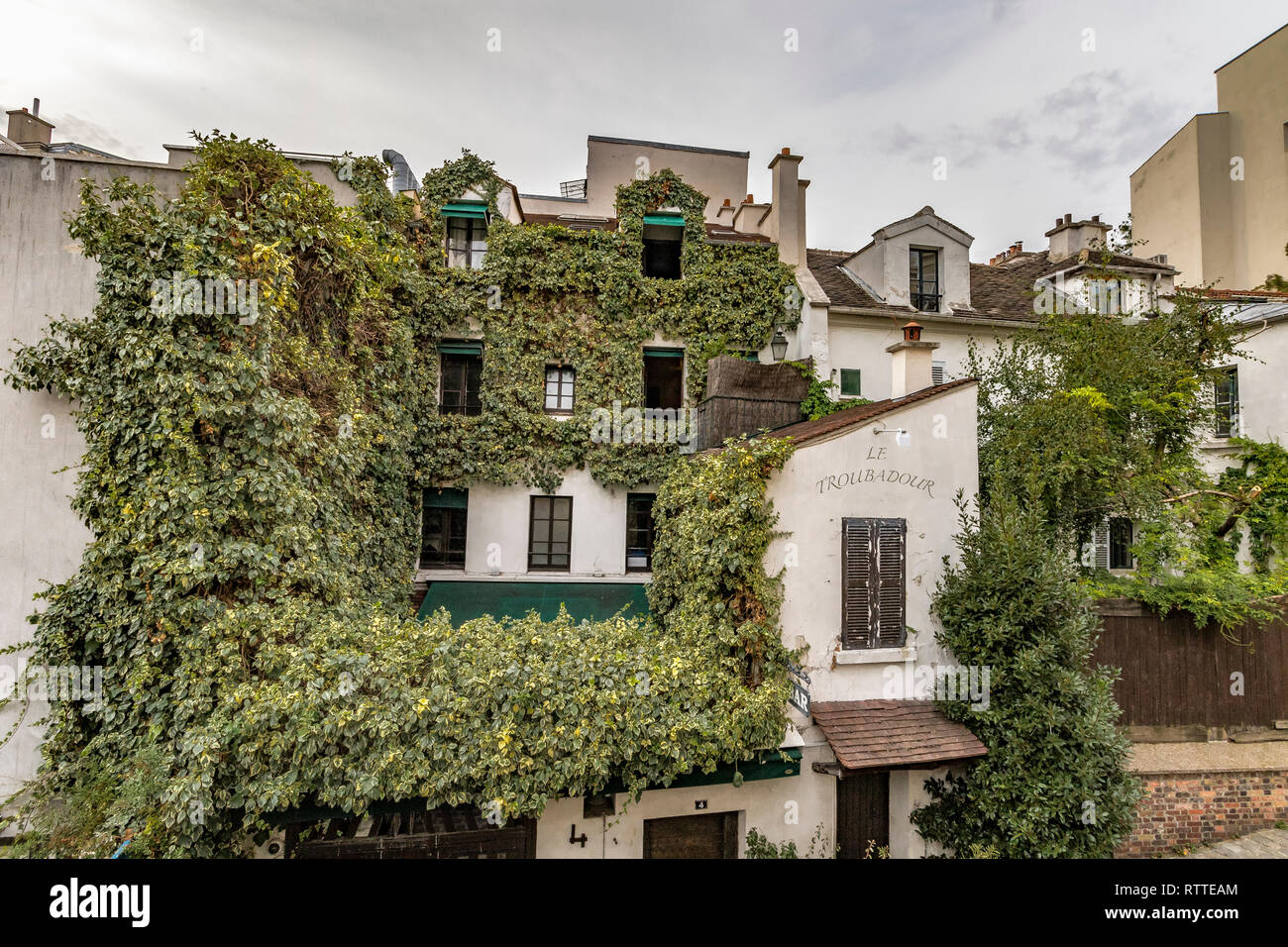 Ivy crescente sul muro di una casa di Montmartre che alloggia il Le Troubadour ristorante cafe, Parigi, Francia Foto Stock