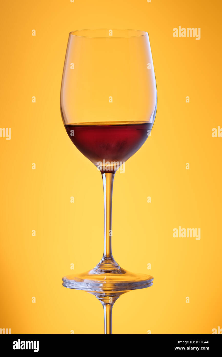Buon vino dolce in un vetro in giallo back lit formato verticale Foto Stock