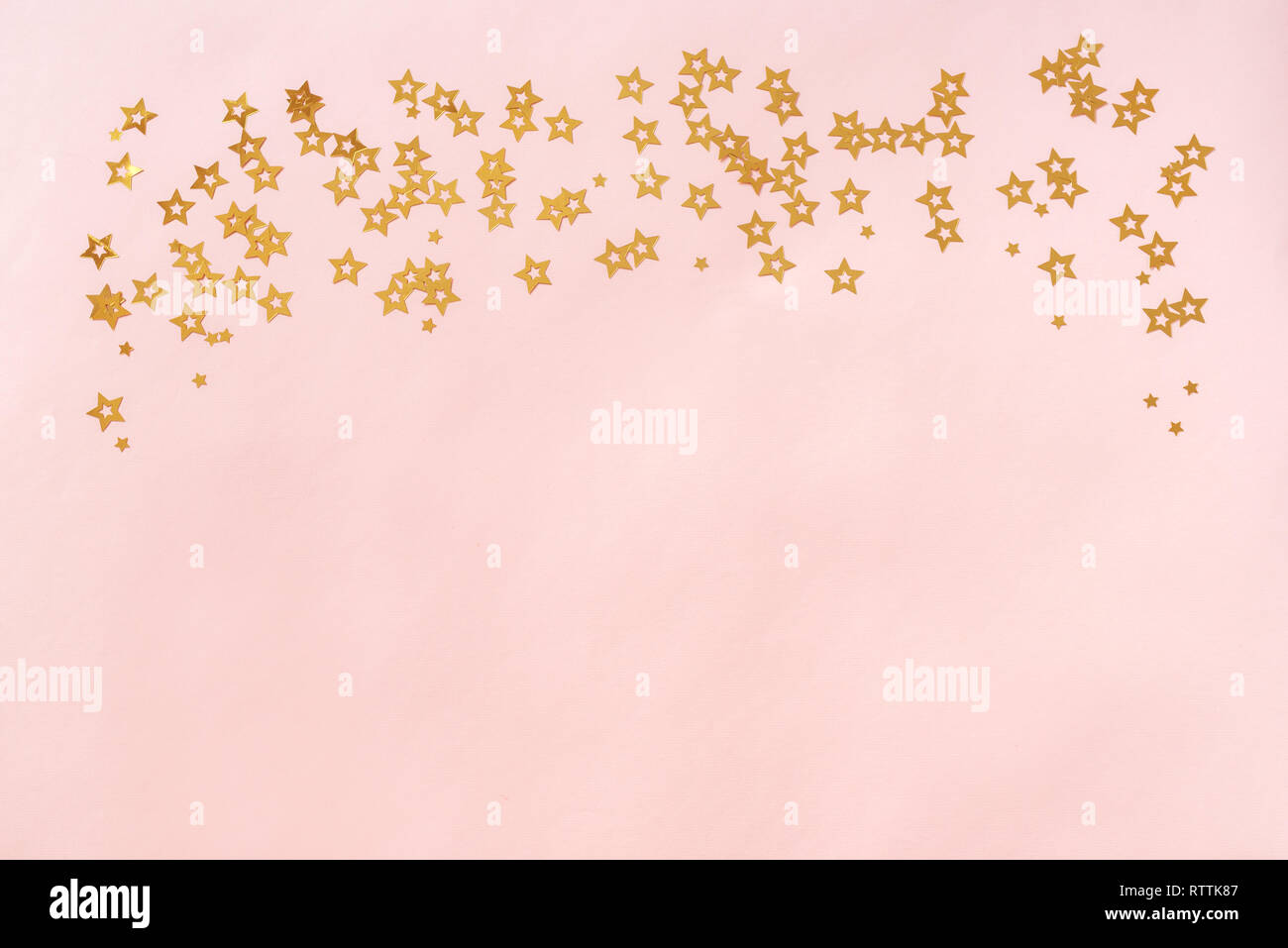 Sfondo rosa con stelle, copia dello spazio. Golden Stars confetti sul pastello sullo sfondo di corallo, mockup. Foto Stock