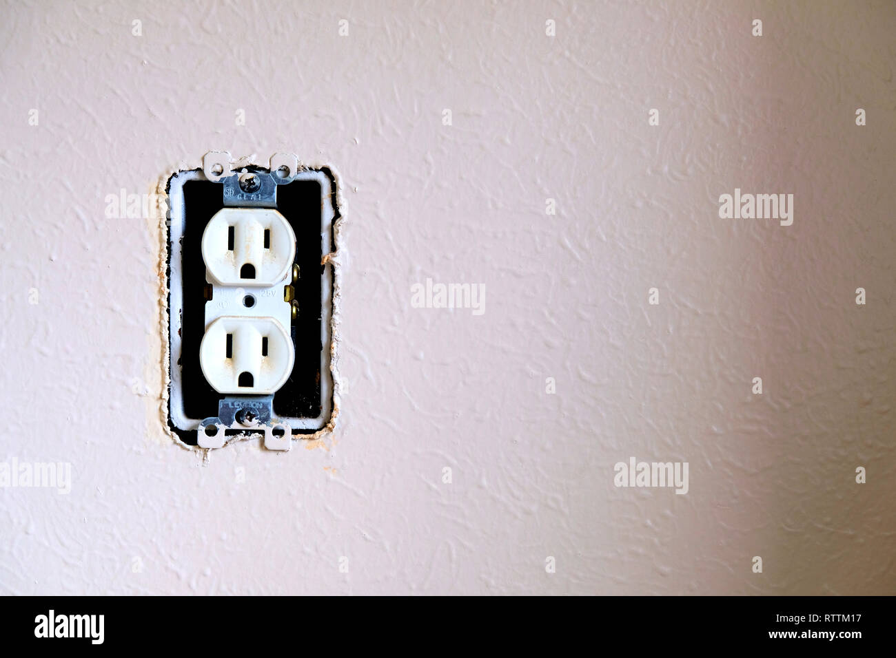 Interno non protetto presa a parete; American presa elettrica mancante di una piastra a parete. Foto Stock