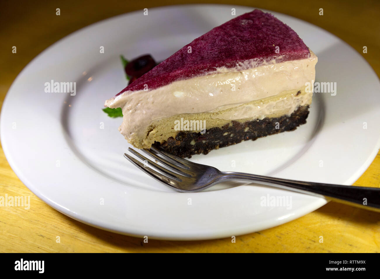 Cheesecake servita con una forchetta. La torta ha muliple strati. Foto Stock