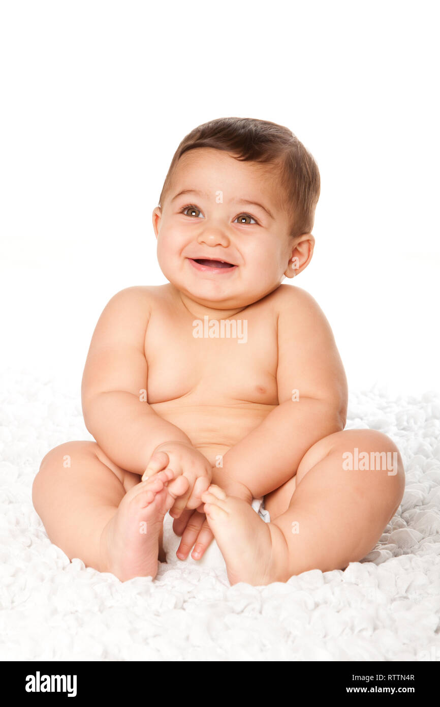 Carino sorridenti innocente neonato Bambino con grande luce verde seduta gli occhi indossando pannolino, infanzia concetto, su bianco. Foto Stock
