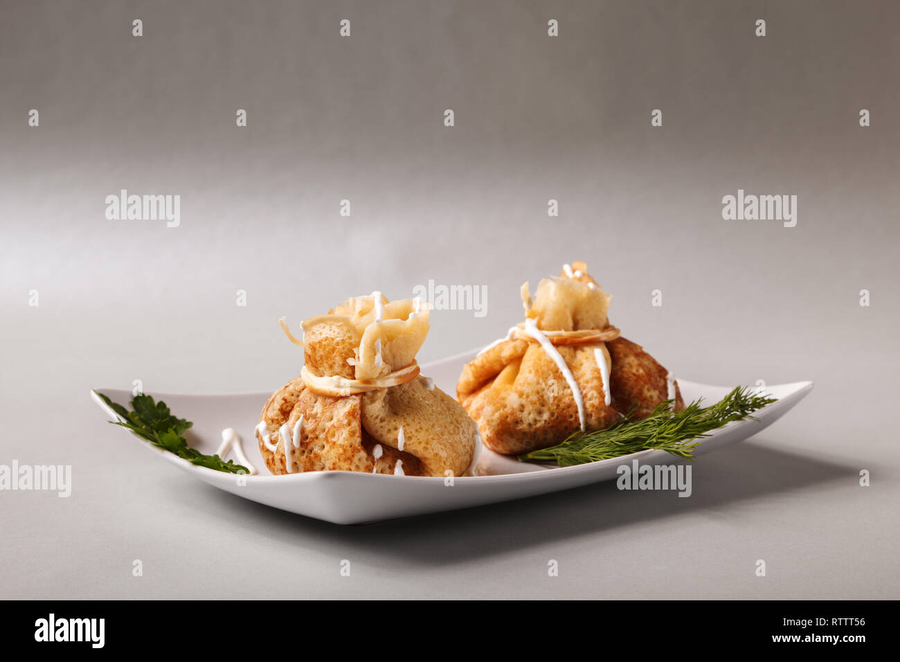 Frittelle con carne, erbe e panna acida - tradizionale per pancake russo settimana Maslenitsa - spring festival.Felice Martedì Grasso Foto Stock