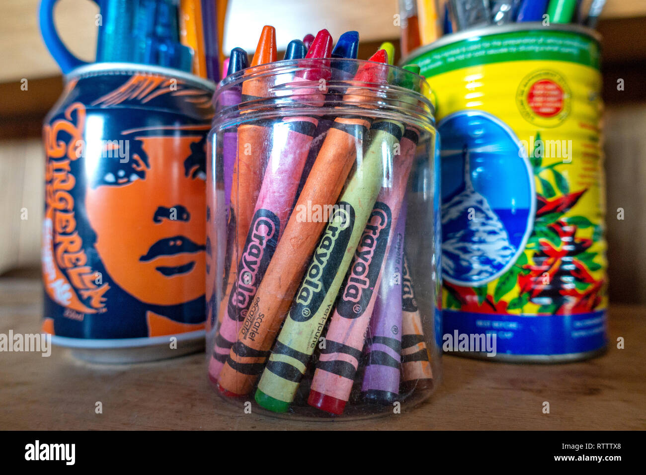 Due Grafica Retrò progettato arte antica Fairtrade lattine di lattina colorato contenente penne e matite colorate Foto Stock