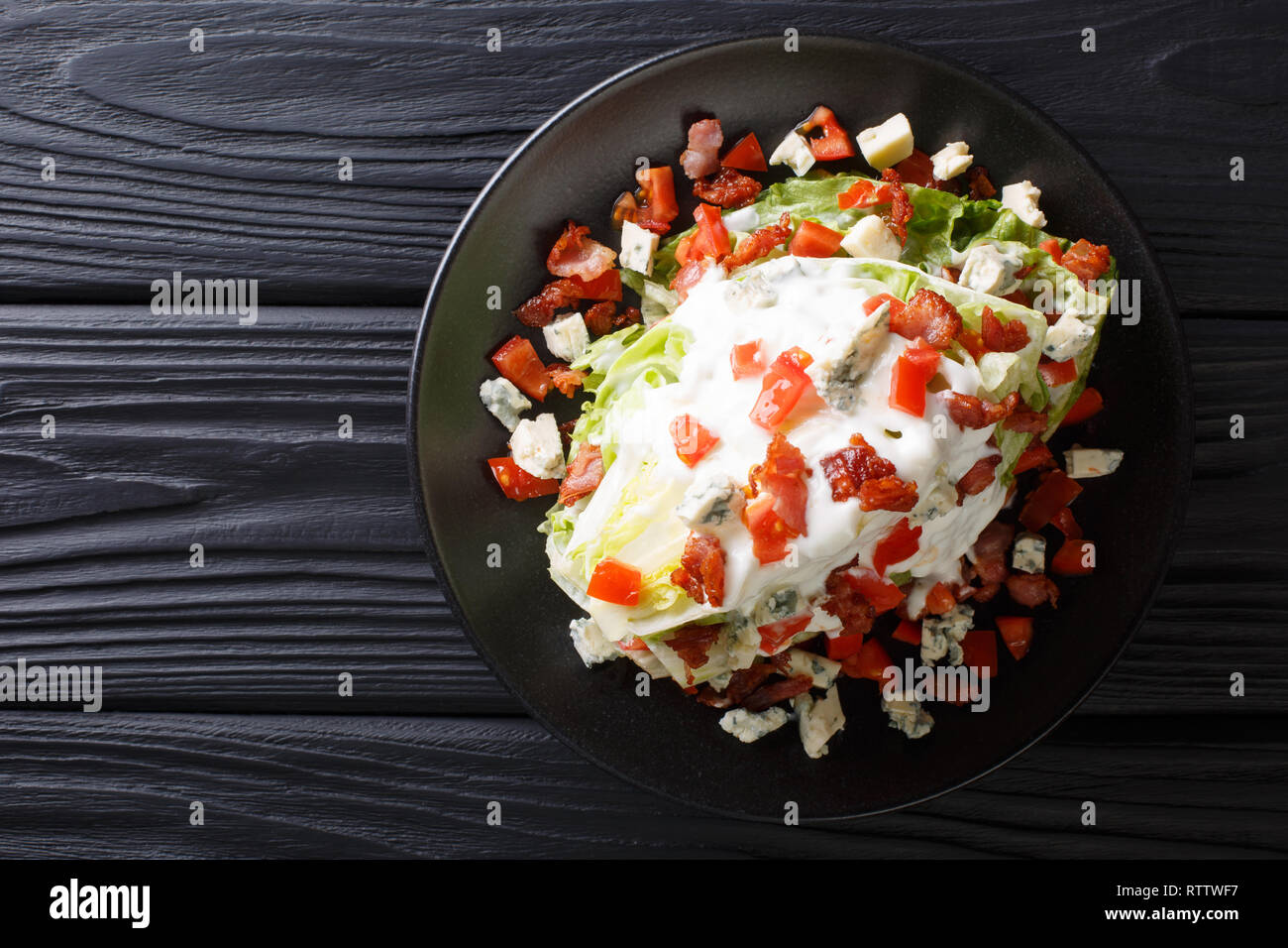 Cuneo americano con insalata di lattuga iceberg, condimento a base di formaggio erborinato, pancetta croccante e pomodori freschi closeup su una piastra sul tavolo. parte superiore orizzontale vie Foto Stock