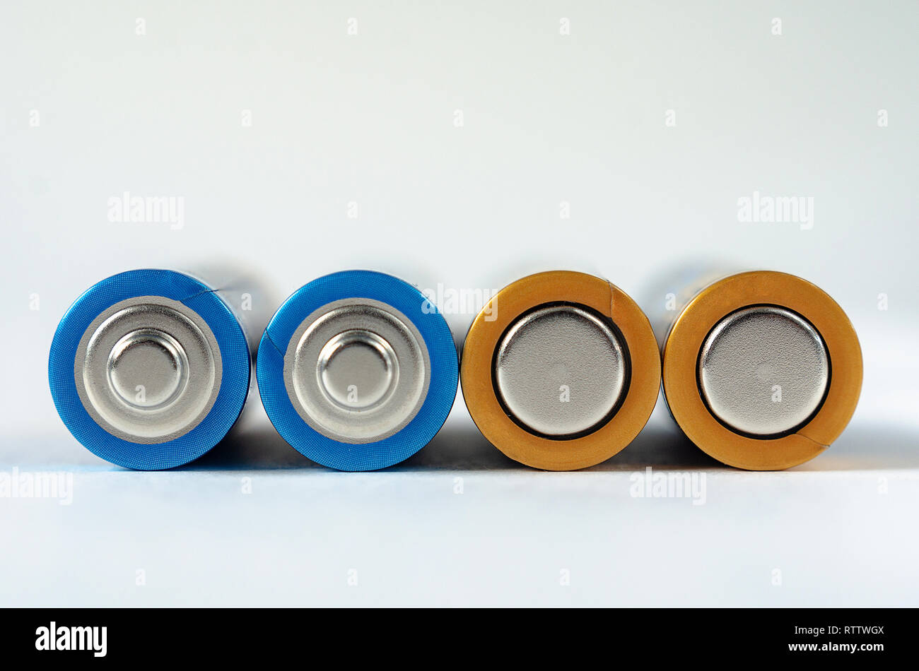 Quattro blue-golden batterie AA close-up su uno sfondo bianco. La profondità di campo di una macro. Foto Stock