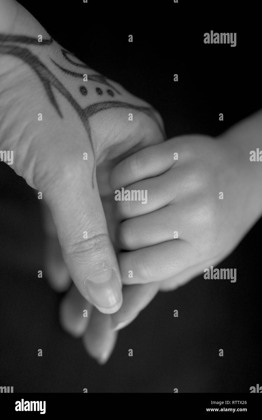 Madre tenendo le sue figlie mano, tattoo sulle madri mano Foto Stock