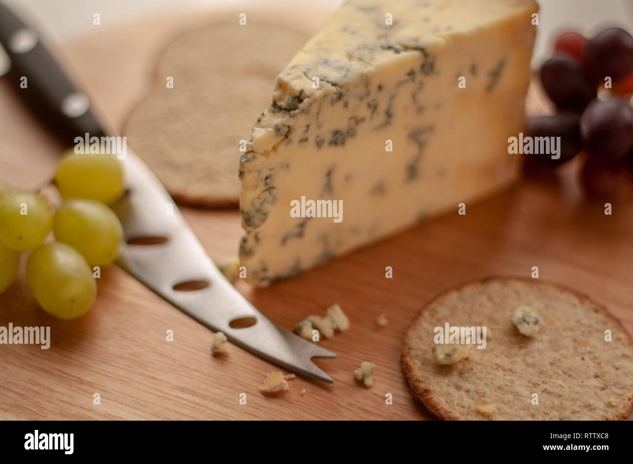 Uve di formaggio e i biscotti su una scheda di formaggio Foto Stock