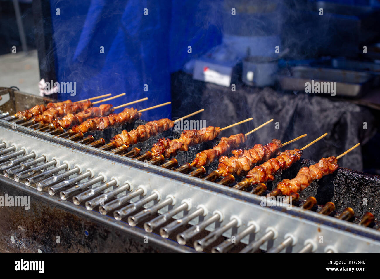 Christchurch Square, Christchurch, Nuova Zelanda, 2 Marzo 2019: spiedini di carne di maiale o il barbecue spiedini di essere preparato per la vendita in un mercato alimentare per le Filippine giorno Foto Stock