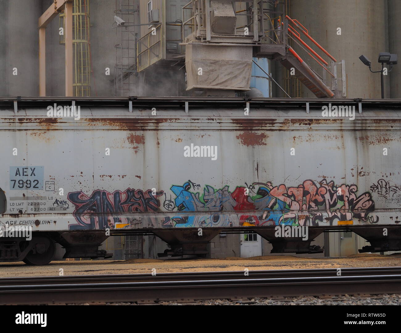 Caricamento di grano in un coperto di graffiti vagone ferroviario in Circleville Ohio wide shot Foto Stock