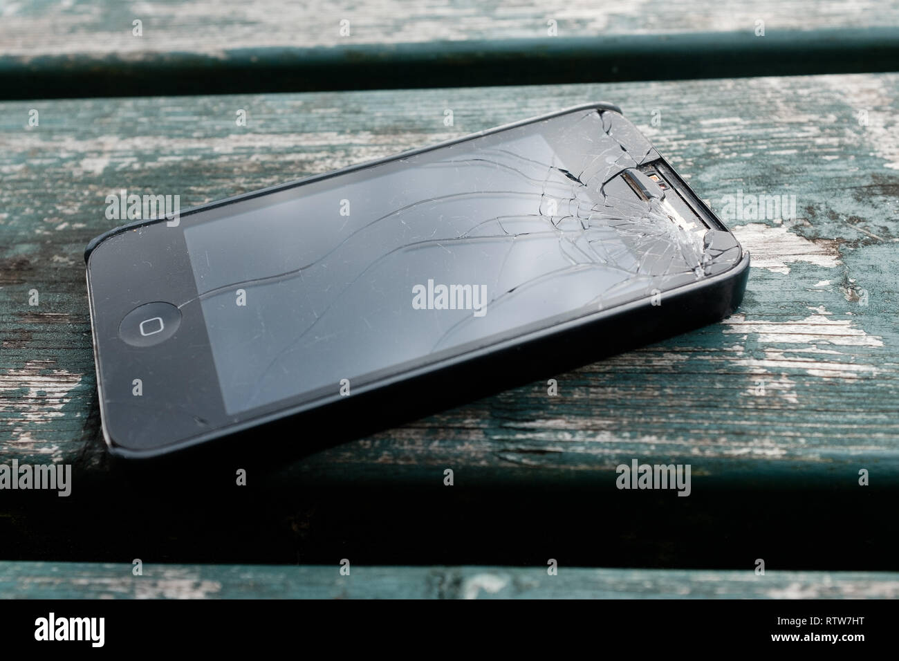 Un fracassato iphone 4 si trova sulla parte superiore del banco di legno che mostra una schermata fracassato e altri danni,Fort William Highlands scozzesi Scotland Regno Unito Foto Stock Un fracassato iphone 4 si trova sulla parte superiore del banco di legno che mostra una schermata fracassato e altri danni,Fort William Highlands scozzesi Scotland Regno Unito Foto Stock