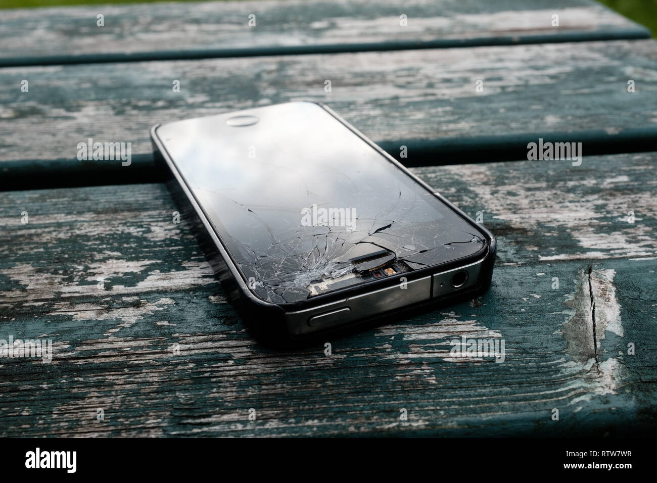 Un fracassato iphone 4 si trova sulla parte superiore del banco di legno che mostra una schermata fracassato e altri danni,Fort William Highlands scozzesi Scotland Regno Unito Foto Stock Un fracassato iphone 4 si trova sulla parte superiore del banco di legno che mostra una schermata fracassato e altri danni,Fort William Highlands scozzesi Scotland Regno Unito Foto Stock