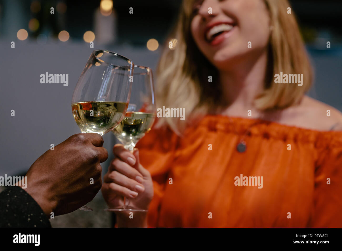 L uomo e la donna la tostatura su data la notte. Donna sorridente tostare il bicchiere di vini con il suo fidanzato. Foto Stock