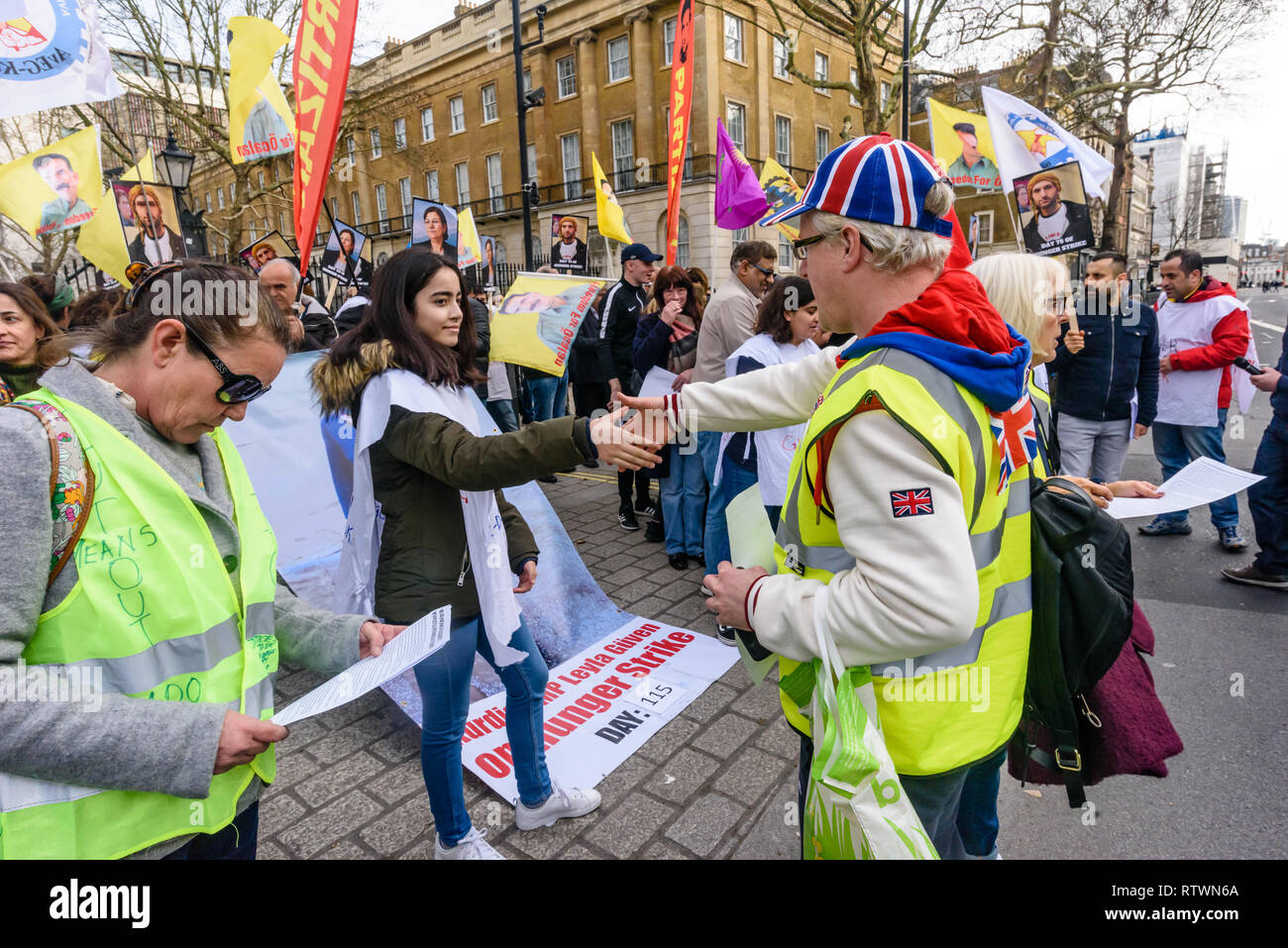 Londra, Regno Unito. 2 marzo 2019. Giubbotti di giallo UK venuto a parlare e agitare le mani con curdo scioperanti della fame che protestano contro la repressione turca e a mostrare solidarietà con scioperanti della fame arriva a Downing St. essi si è congratulato con loro per stare in piedi per i loro diritti, anche se politicamente i due gruppi sono molto distanti. Alcuni indossano giubbetti giallo è venuto fino a parlare con i curdi, e scosse le mani del Regno Unito scioperanti della fame, sebbene alcuni curdi ha rifiutato di agitare le mani con la destra contestatori. Credito: Peter Marshall / Alamy Live News Foto Stock