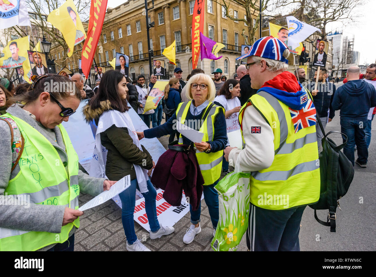 Londra, Regno Unito. 2 marzo 2019. Giubbotti di giallo UK venuto a parlare con curdo scioperanti della fame che protestano contro la repressione turca e a mostrare solidarietà con scioperanti della fame arriva a Downing St. essi si è congratulato con loro per stare in piedi per i loro diritti, anche se politicamente i due gruppi sono molto distanti. Alcuni indossano giubbetti giallo è venuto fino a parlare con i curdi, e scosse le mani del Regno Unito scioperanti della fame, sebbene alcuni curdi ha rifiutato di agitare le mani con la destra contestatori. Credito: Peter Marshall / Alamy Live News Foto Stock