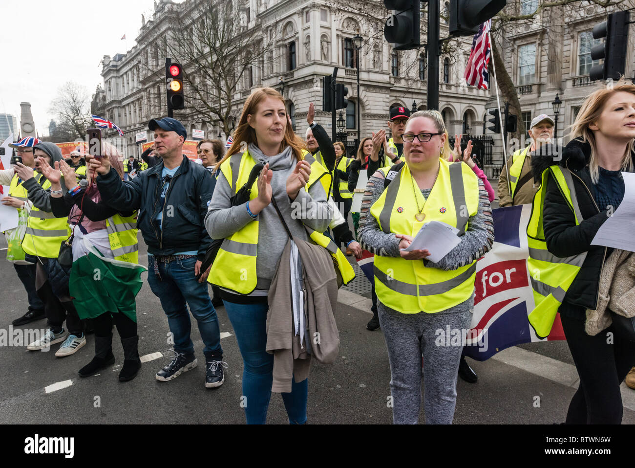 Londra, Regno Unito. 2 marzo 2019. Manifestanti curdi marciare contro la repressione turca e a mostrare solidarietà con scioperanti della fame sono stati accolti con applausi prolungati dal Giubbotto giallo UK manifestanti come sono arrivati a Downing St. erano congratulati con per alzarsi per i propri diritti anche se politicamente i due gruppi sono molto distanti. Alcuni indossano giubbetti giallo è venuto fino a parlare con i curdi, e scosse le mani del Regno Unito scioperanti della fame, sebbene alcuni curdi ha rifiutato di agitare le mani con la destra contestatori. Credito: Peter Marshall / Alamy Live News Foto Stock