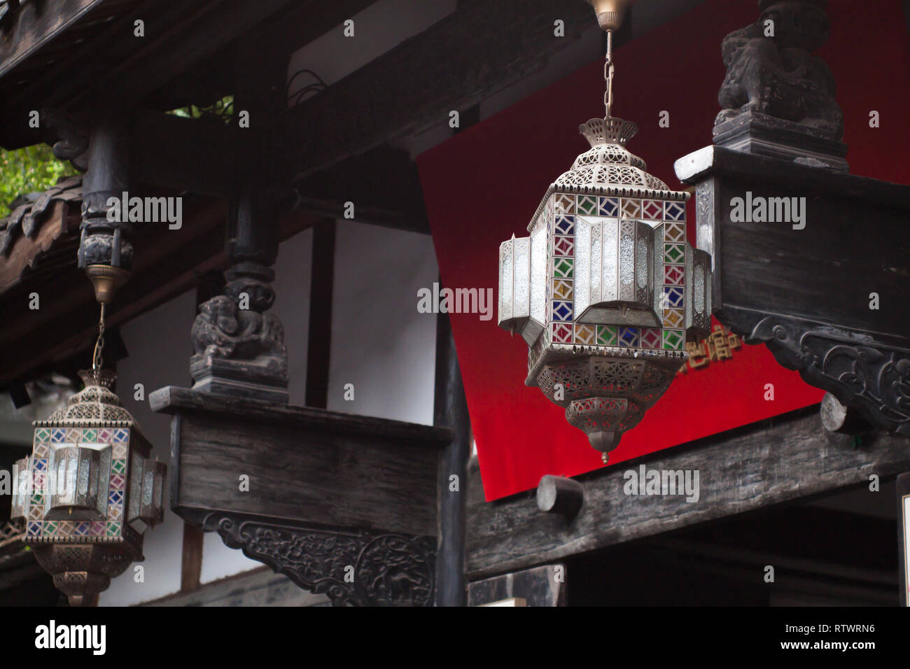 Design orientale Lantern davanti a un cinese tradizionale edificio in legno. Argento Lanterna di Metallo con vetro colorato di inserti. Foto Stock