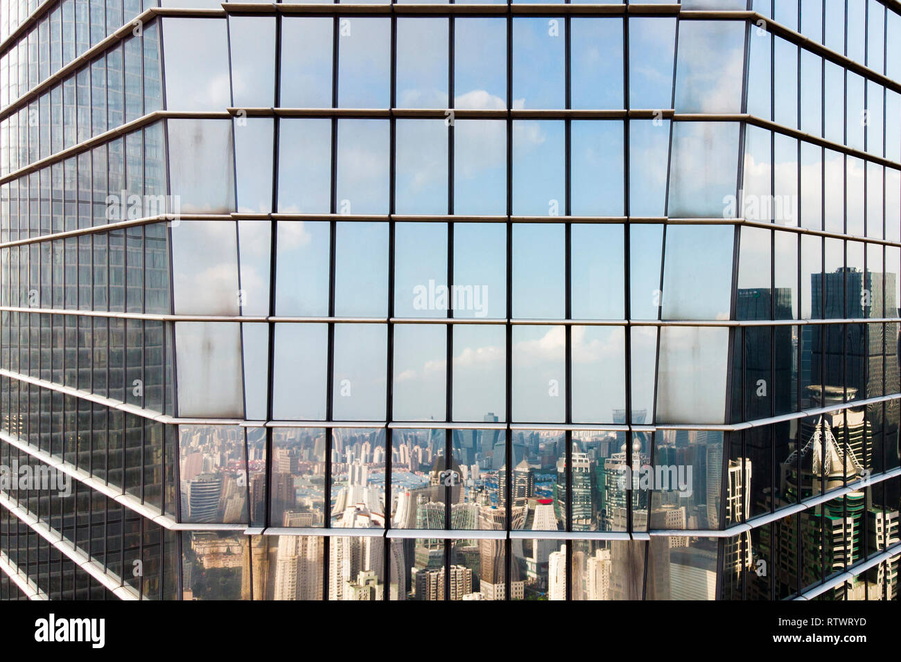 La facciata in vetro con angolo di riflessione e della skyline della città moderna. Skyline riflessa sulla parete di tamponamento di elevazione. Foto Stock