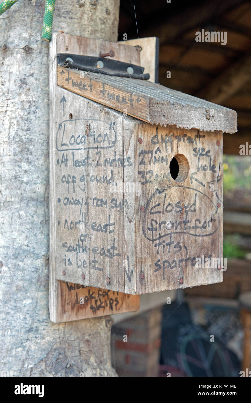 Nestbox in legno con consigli per la sua ubicazione e per il quale specie di uccelli sono suscettibili di utilizzare tale tipo di scatola è scritto su di esso. Foto Stock