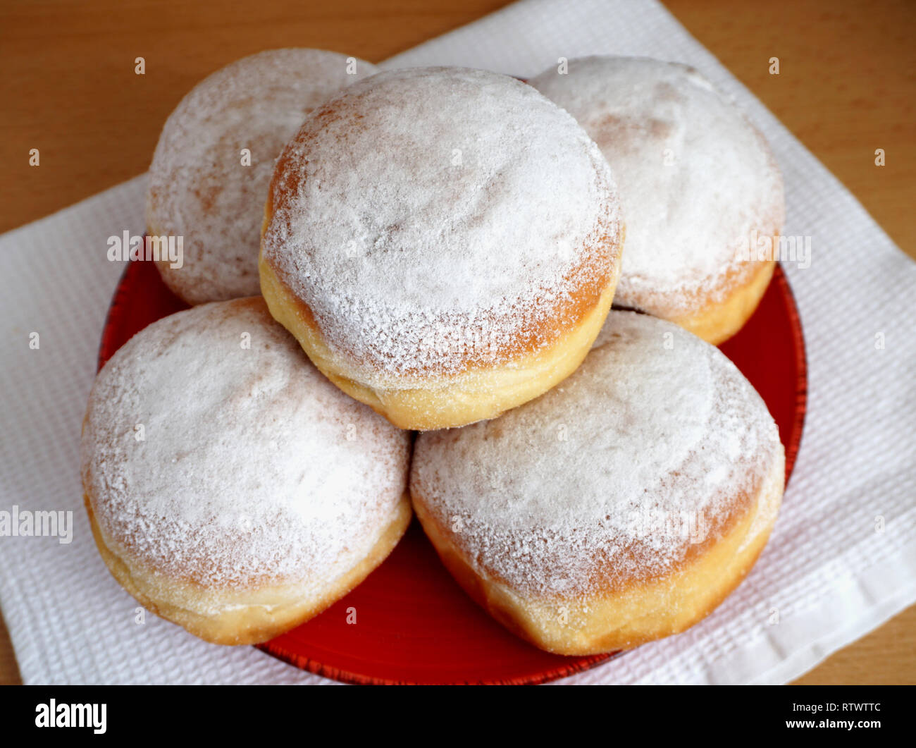 In casa una gustosa frittella ciambelle preparate dalla pasta madre dalla vecchia ricetta su la targhetta rossa, dall'alto. Foto Stock