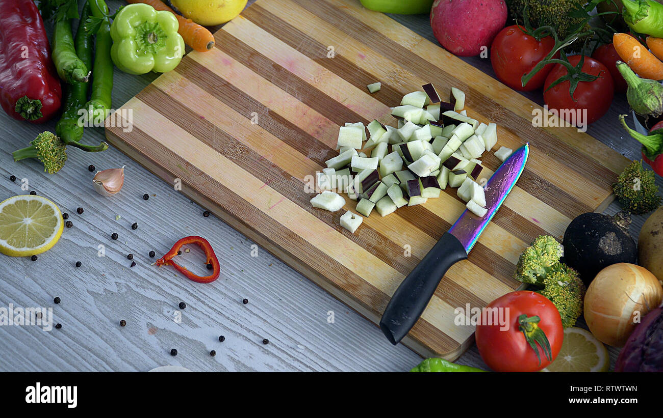 L uomo è il taglio di vegetali in cucina, affettare la melanzana Foto Stock